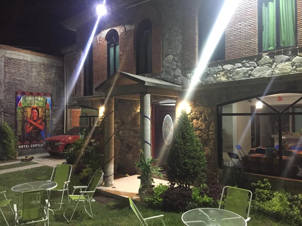 a house with chairs and tables in the yard at night at Hotel Coatlicue in San Juan Teotihuacán