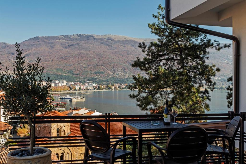 uma mesa e cadeiras numa varanda com vista para um lago em Villa Sofija em Ohrid