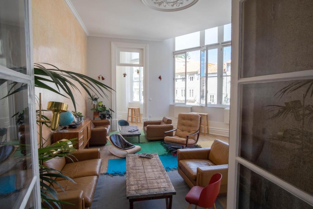 
a living room filled with furniture and a window at Dona Emília Guest House in Viana do Castelo
