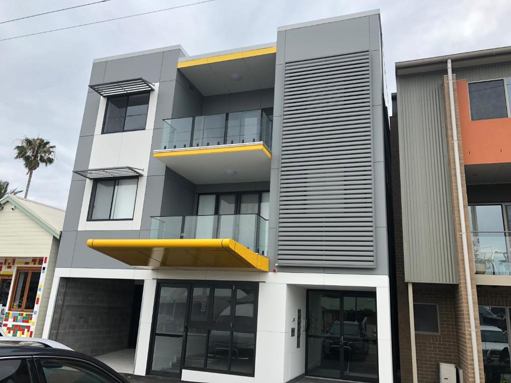 a modern apartment building with a yellow balcony at Quattro On Young in Newcastle