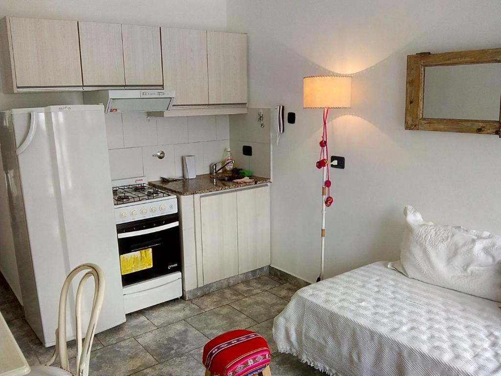 a small kitchen with a white refrigerator and a bed at DTO SERRANO in Tandil