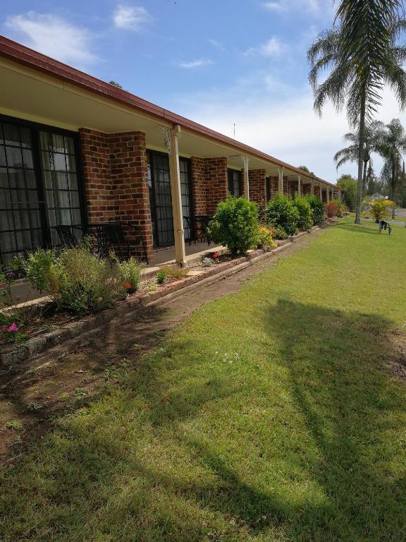 a building with a grass yard in front of it at Lakeside Lodge Motel in Lismore