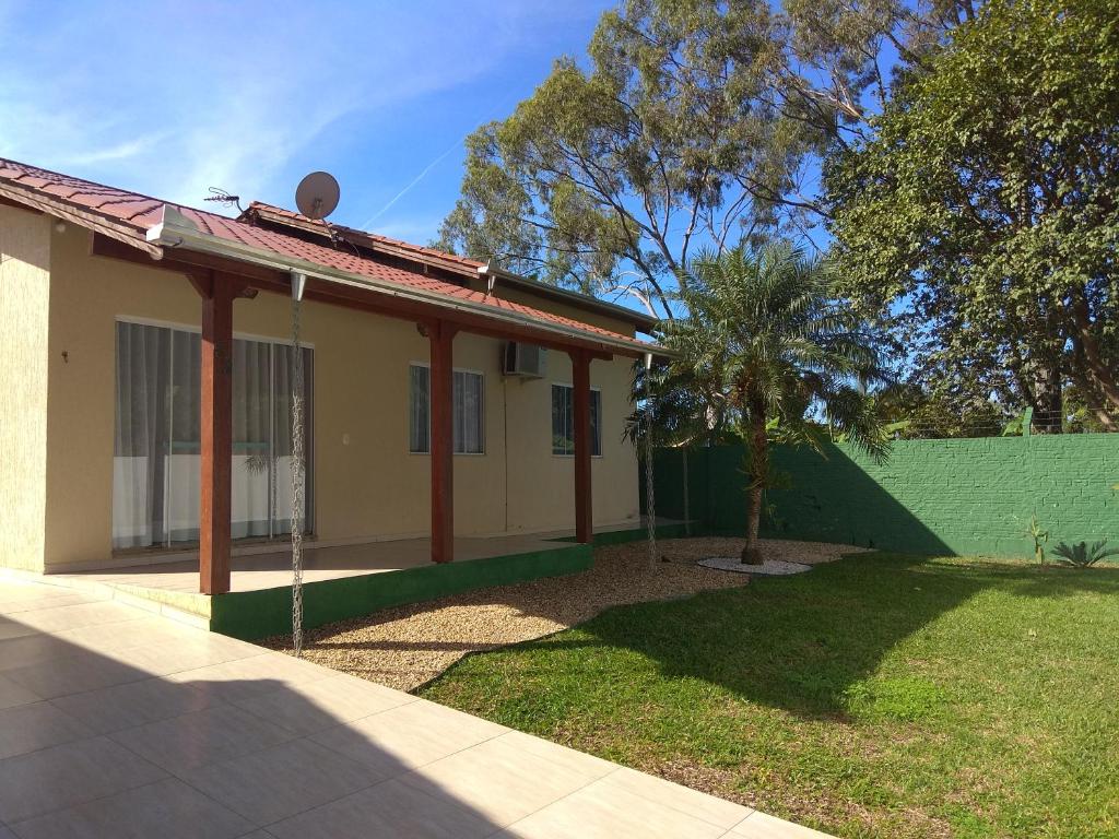 une maison avec un palmier dans la cour dans l'établissement Casa paraíso estaleirinho Balneário Camboriú, à Balneário Camboriú