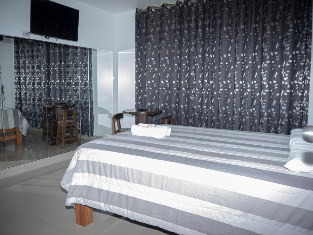 Hostal Sueños في ليما: غرفة نوم بسرير وبطانية بيضاء وسوداء