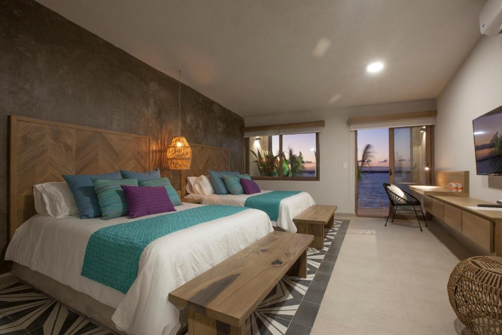 a hotel room with two beds and a desk at Casa al Mar in La Paz