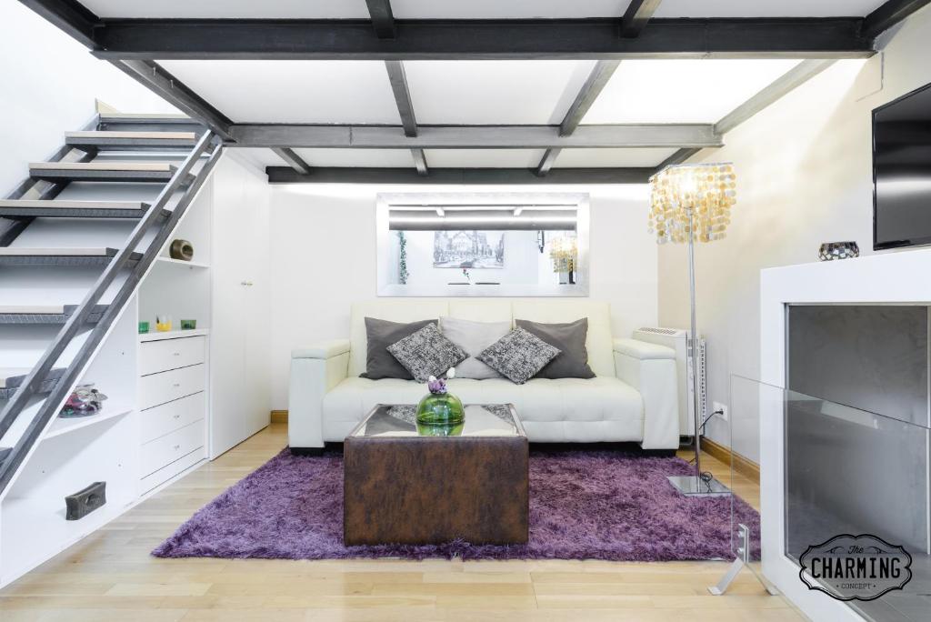 a living room with a white couch and a fireplace at Charming Fuencarral Street in Madrid