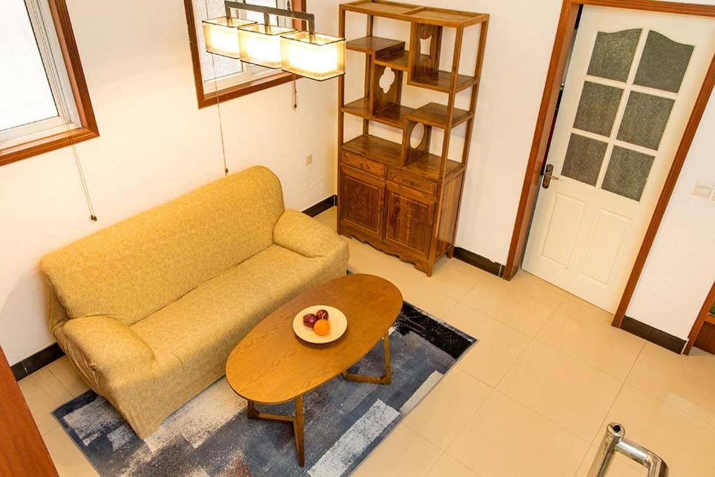 uma sala de estar com um sofá e uma mesa em Henan Kaifeng·Millennium City· Locals Apartment 00139400 em Kaifeng