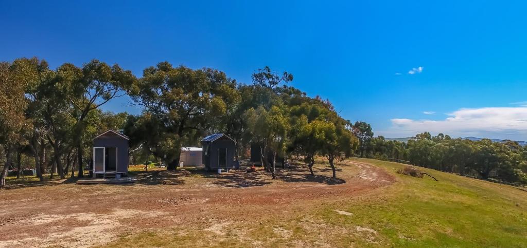 uma casa numa colina com árvores ao fundo em Hilltop Tiny House em Tallarook