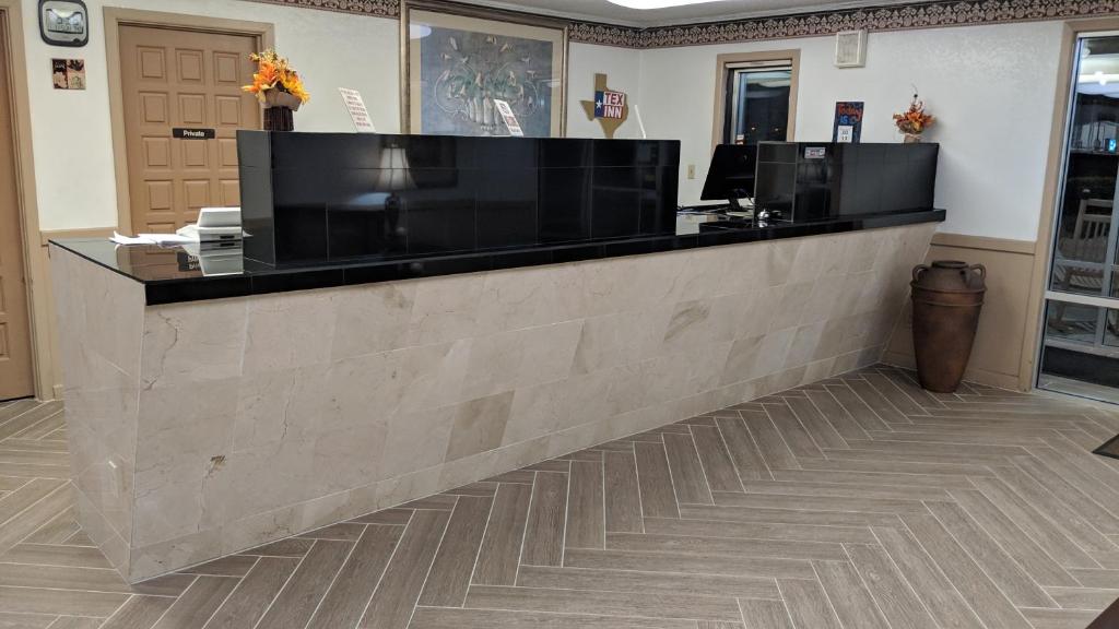 a lobby with a counter with two monitors on it at TexInn Motel New Boston in New Boston