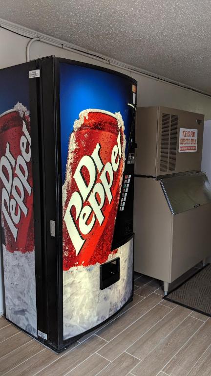 a soda machine with a picture of a coke bottle at TexInn Motel New Boston in New Boston