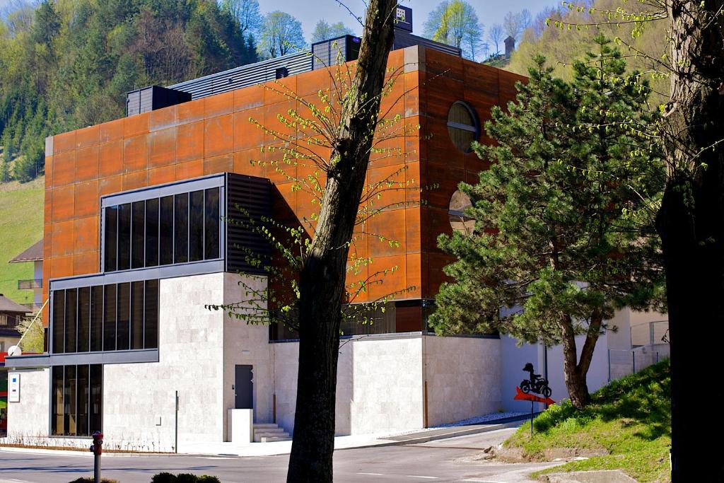 un bâtiment avec un arbre en face dans l'établissement Hotel Jozef, à Idrija