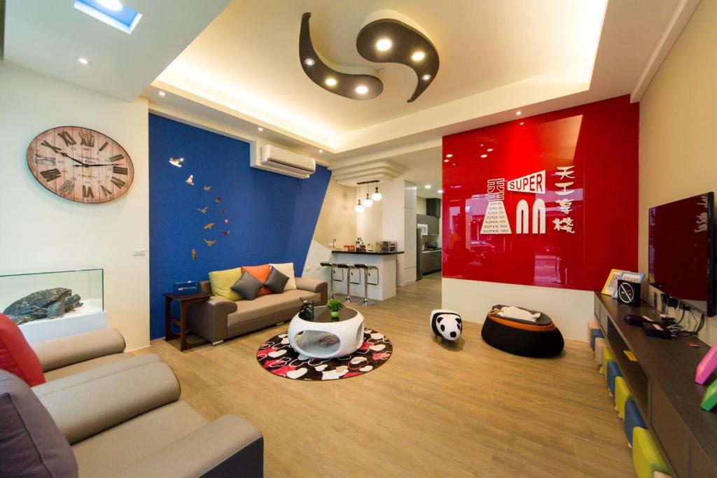 een woonkamer met een bank en een klok aan de muur bij Tiangong Super Inn homestay in Hengchun