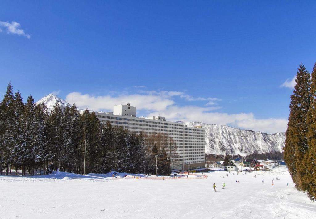 una stazione sciistica con un edificio nella neve di Hotel Angel Grandia Echigo Nakazato a Yuzawa