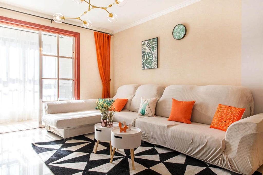 a living room with a white couch and orange pillows at Henan Kaifeng·Henan University· Locals Apartment 00140700 in Kaifeng