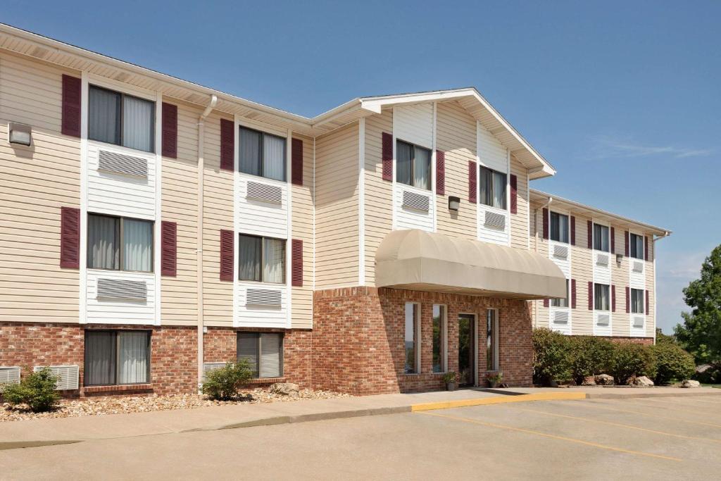 an apartment building with a parking lot in front of it at Travelodge by Wyndham Jefferson City in Jefferson City