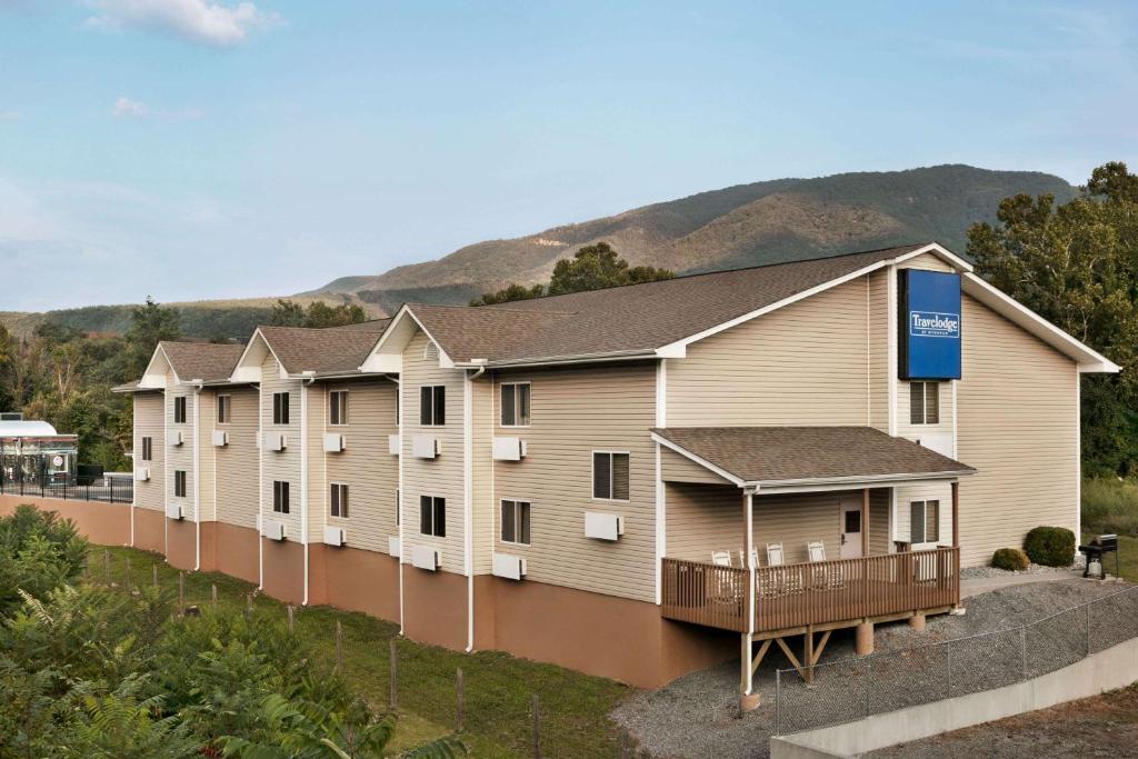 a row of apartment buildings with mountains in the background at Travelodge by Wyndham Low Moor Near Covington in Low Moor