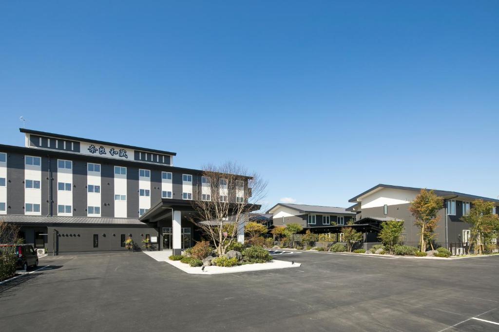 un hotel con un estacionamiento delante de él en GRANDVRIO HOTEL NARA -WAKURA- -ROUTE INN HOTELS-, en Tenri