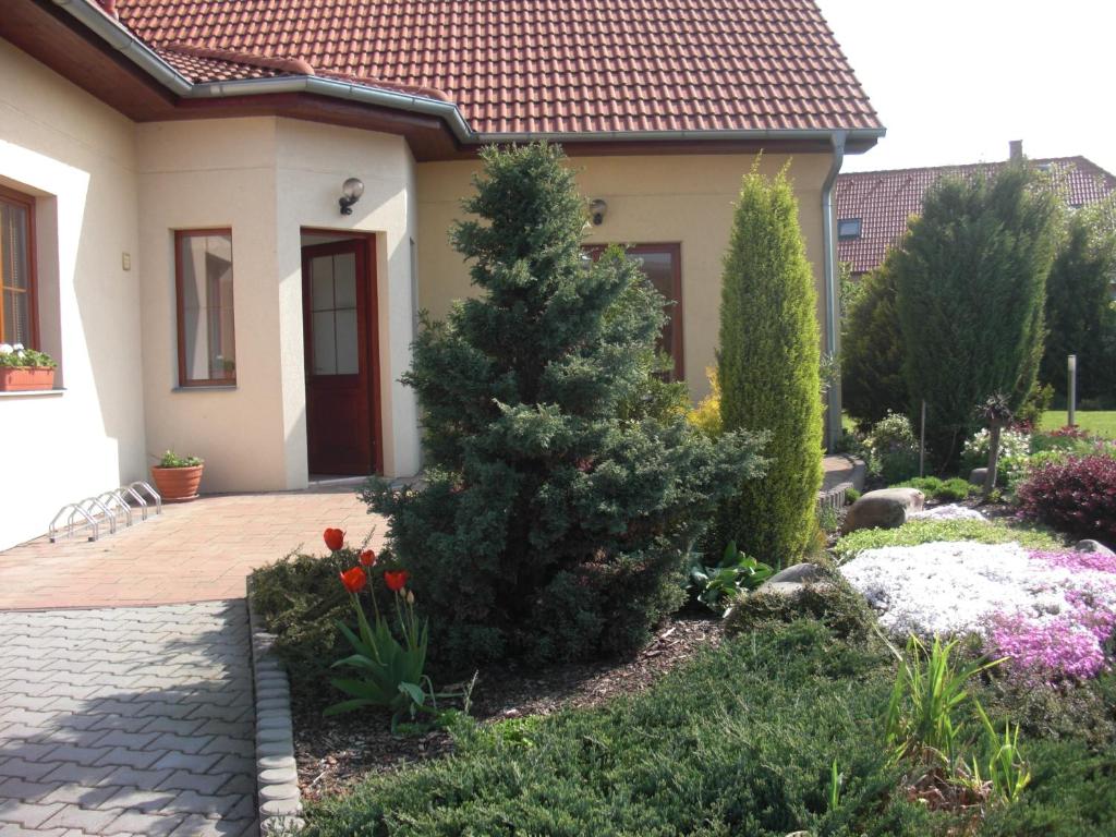 
a small house with a flower garden in front of it at Pension Olga in Klecany
