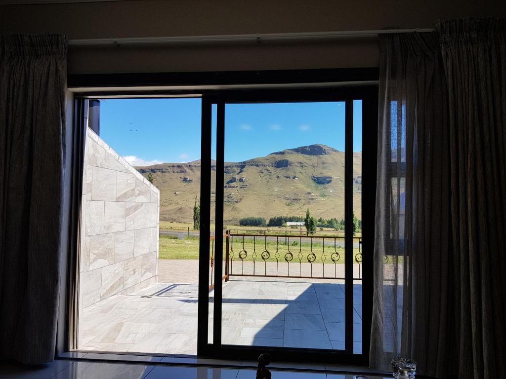 a sliding glass door with a view of a mountain at WILLOW MANOR in Clarens