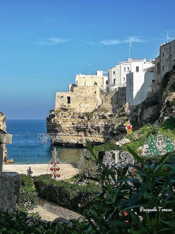 a building on a cliff next to the ocean at Casa Raffaella in Polignano a Mare