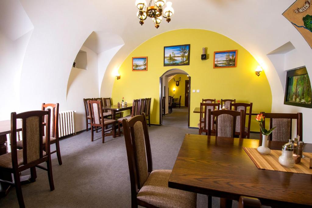 a dining room with wooden tables and chairs at Rodinný hotel Myslivna in Třeboň