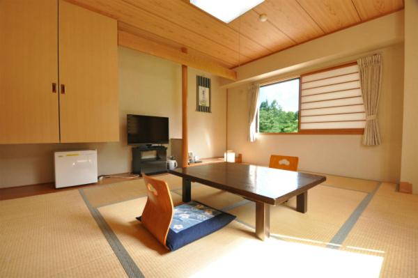a large living room with a table and chairs at Hakuba Yamano Hotel in Hakuba