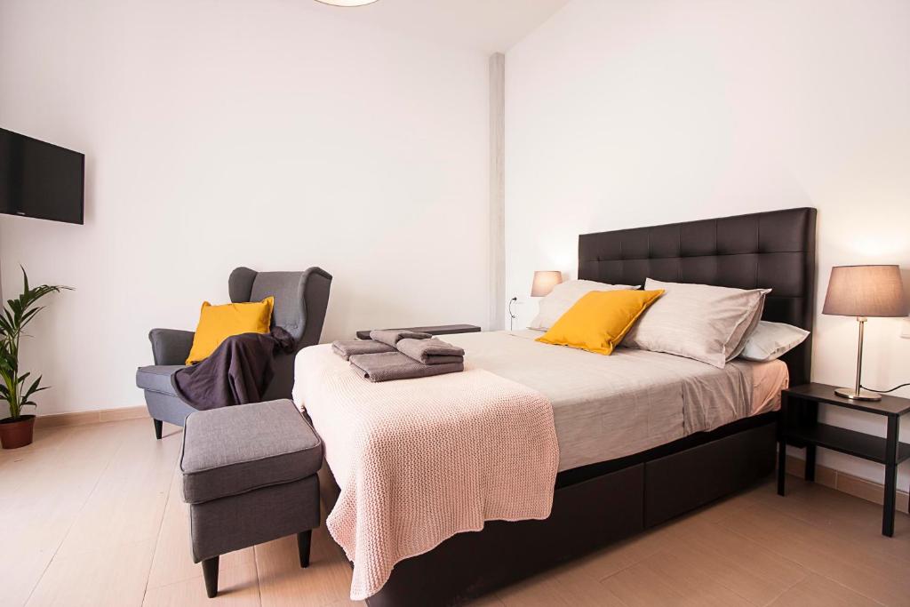 マラガにあるRayito FreshApartments by Bossh! Apartmentsのベッドルーム(大型ベッド1台、椅子付)