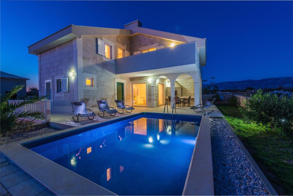 a villa with a swimming pool at night at Villa Stani, luxury villa with a pool in Novalja