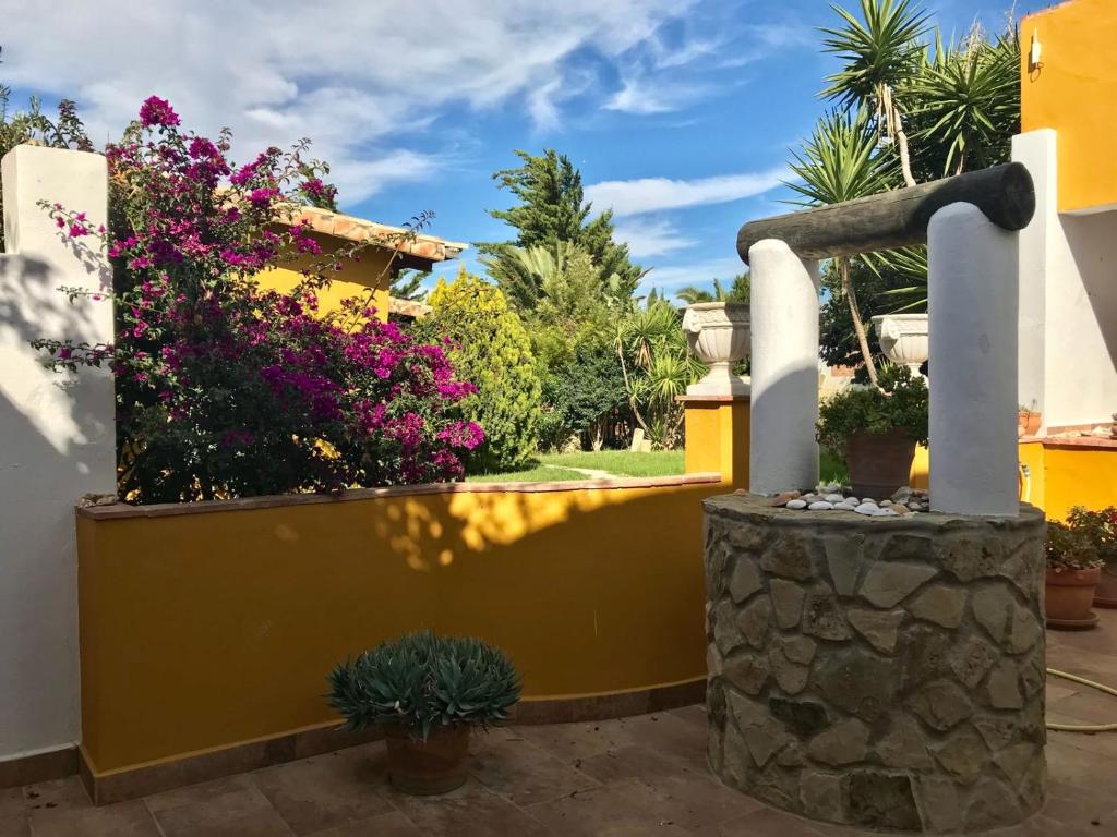 a yellow fence with flowers and plants on it at Casa Entre Armonías in Zahara de los Atunes