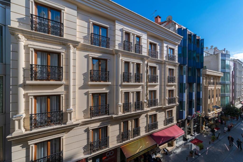 un grand bâtiment blanc avec balcon dans une rue dans l'établissement Vision Deluxe Hotel, à Istanbul