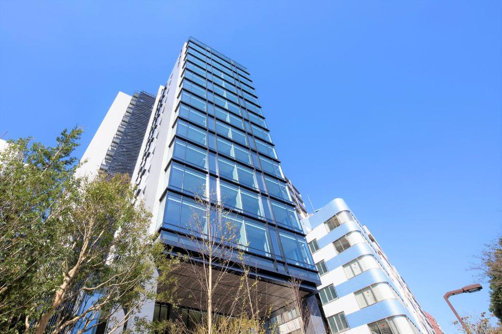 un edificio alto con ventanas de cristal en el lateral. en Hotel Keihan Tsukiji Ginza Grande en Tokio