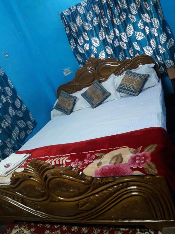 ein Holzbett mit Kissen darüber in der Unterkunft Kiran Guest House in Kalkutta