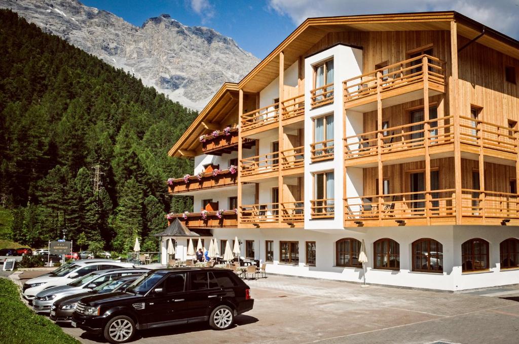a large building with cars parked in a parking lot at Hotel Gertraud in Solda