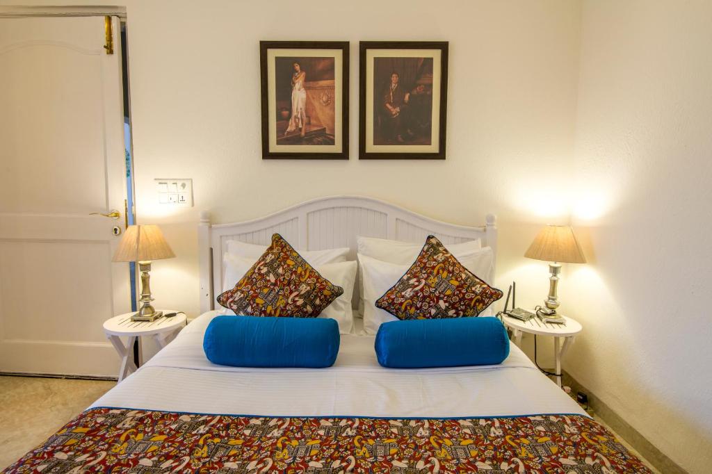 um quarto com uma cama branca e duas mesas em Colonel's Retreat 2 em Nova Deli