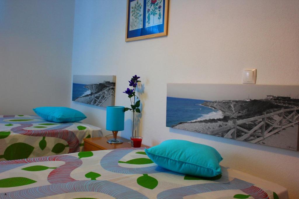 a bedroom with two beds with blue and green pillows at Alfamiano in Alfarim