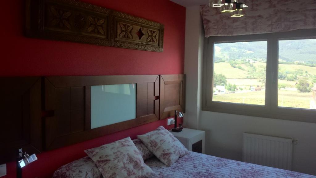 ein Schlafzimmer mit einem Bett und einem großen Fenster in der Unterkunft Apartamentos Ría de Villaviciosa in Villaviciosa