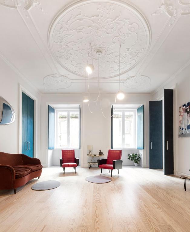 リスボンにあるAwarded 3 bedrooms upscale flat@Chiado Bairro Altoの天井のリビングルーム(ソファ、椅子付)