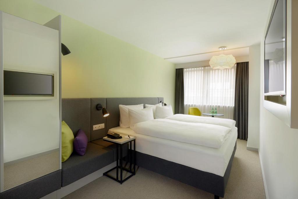 Postel nebo postele na pokoji v ubytování H+ Hotel Wien