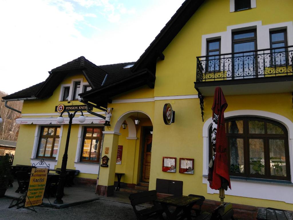 a yellow and white building with a balcony at Penzion Kneifel, s.r.o. in Horní Maršov