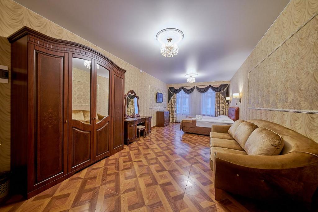 a living room with a couch and a bed at Реверанс отель in Saint Petersburg