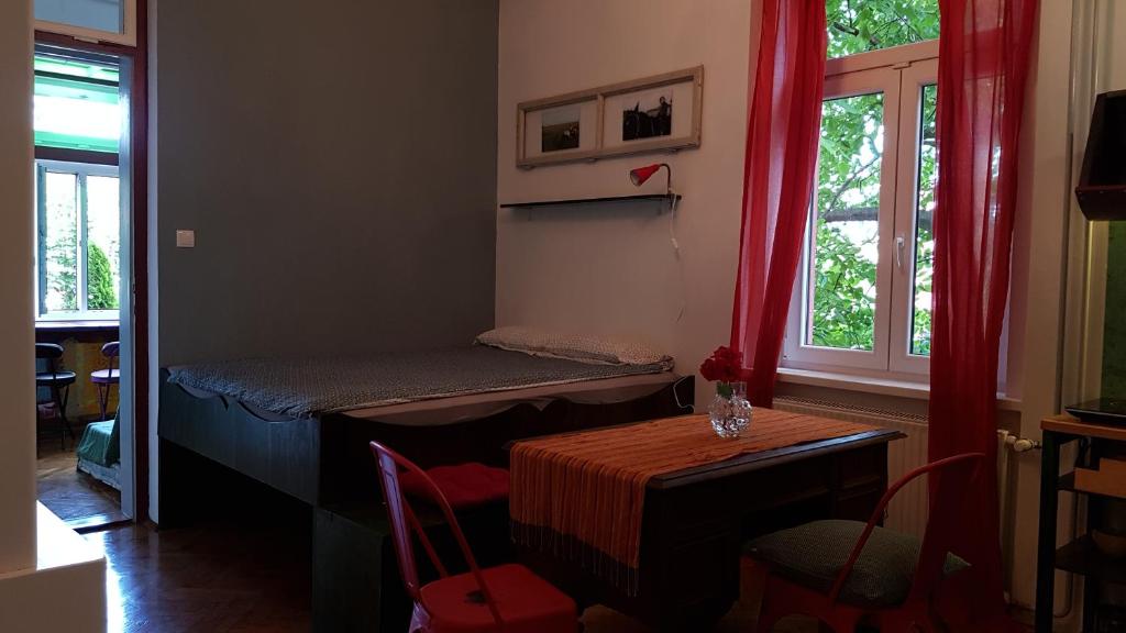 a room with a bed and a table and windows at Villa Coola in Ljubljana