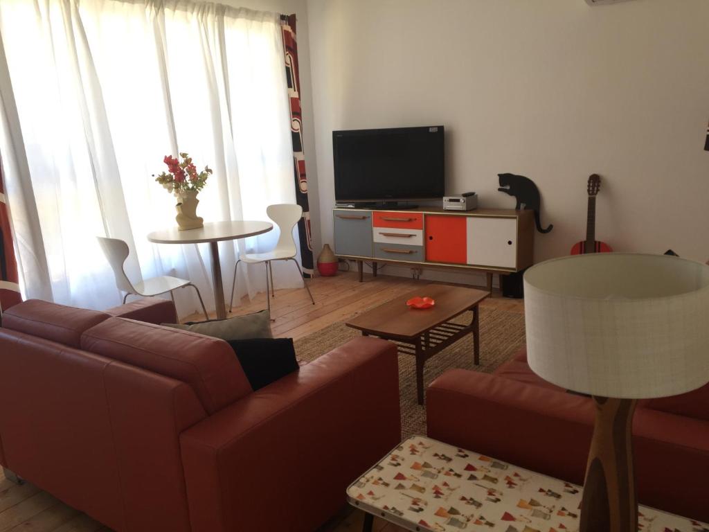 a living room with a couch and a tv at Black Cat Retreat holiday home in Nildottie