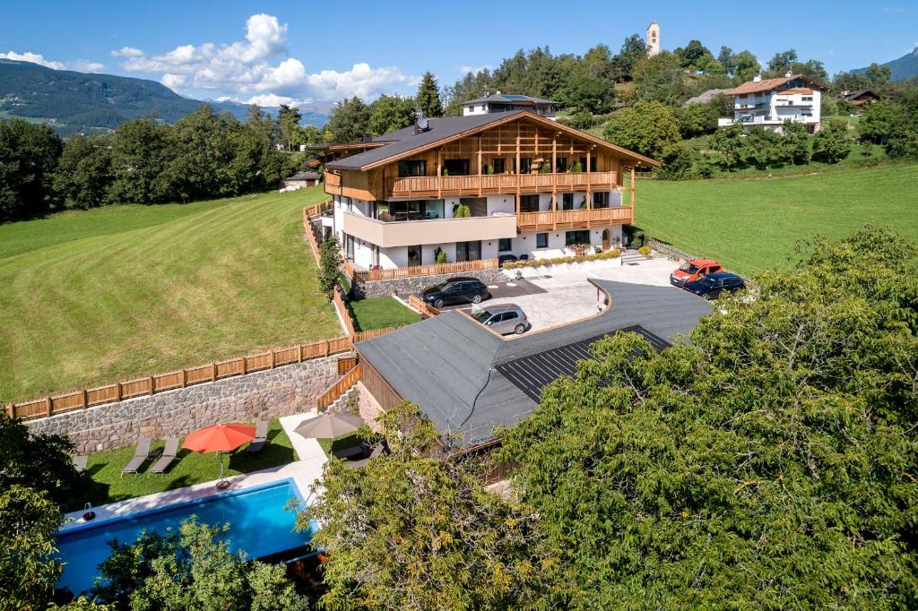 - une vue aérienne sur une grande maison avec une piscine dans l'établissement Hotel Garni Mitterstieler, à Fiè