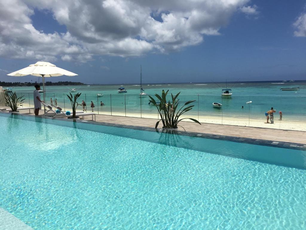 una gran piscina con vistas al océano en OBiches Luxury Beachfront Apartment Trou-aux-Biches, en Trou aux Biches