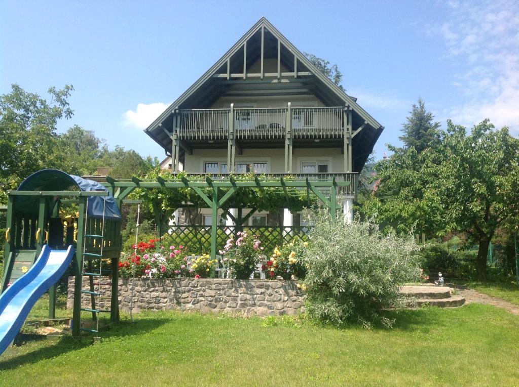 una casa con un tobogán y un parque infantil en Vízközeli panorámás 4 fős apartman Badacsonytomajon, en Badacsonytomaj