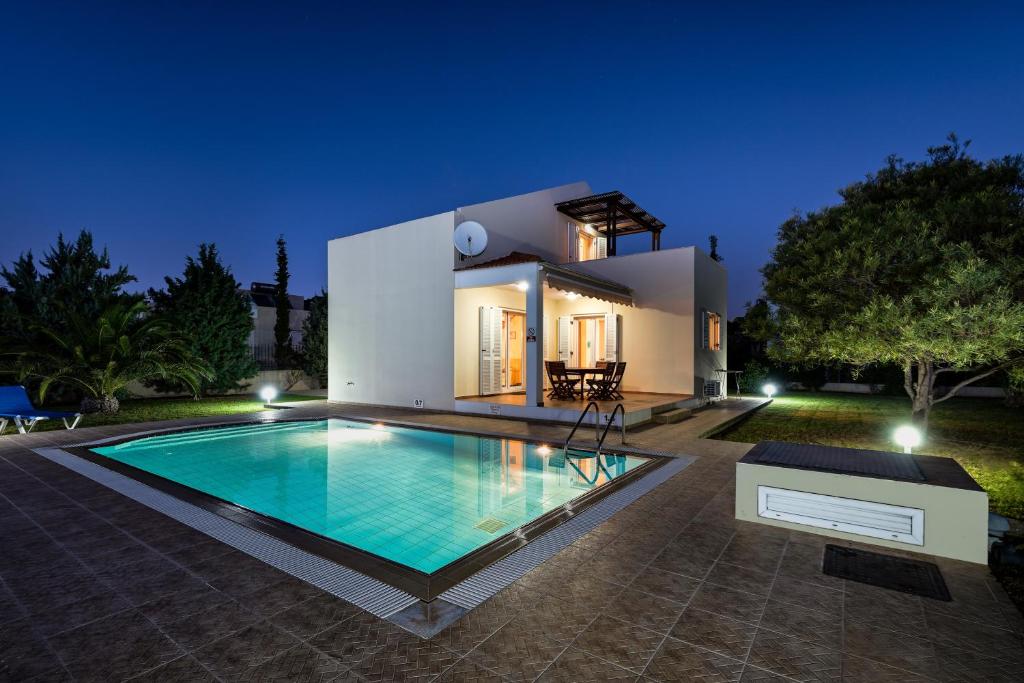 a villa with a swimming pool in front of a house at Olivia Villa in Kolymbia