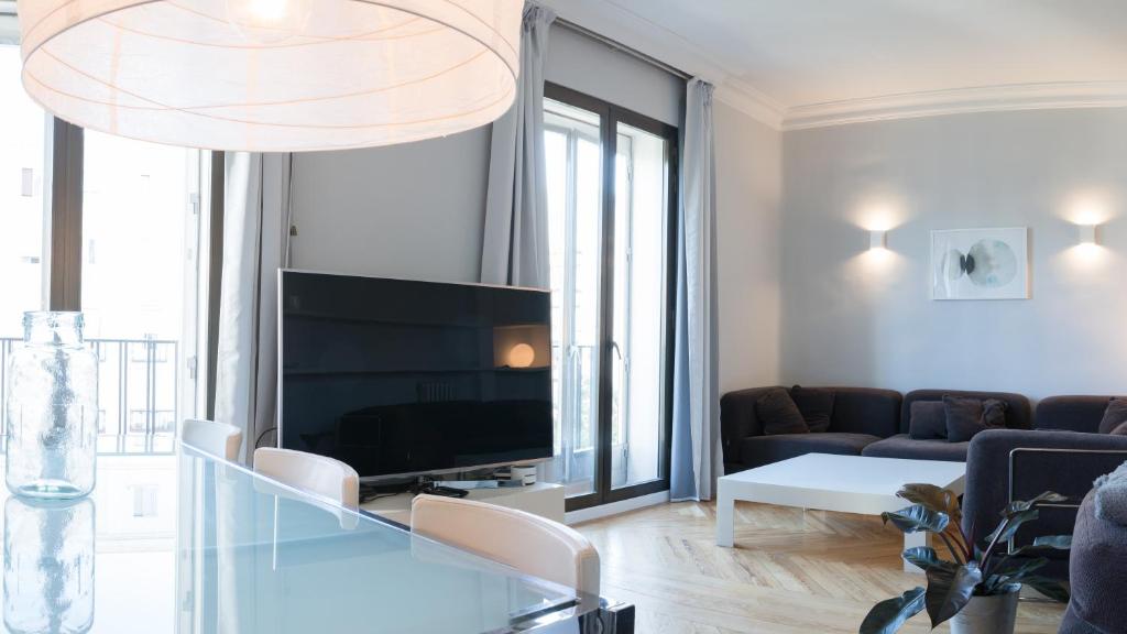 ein Wohnzimmer mit einem TV und einem Sofa in der Unterkunft New Apartment Retiro Park 6pax in Madrid