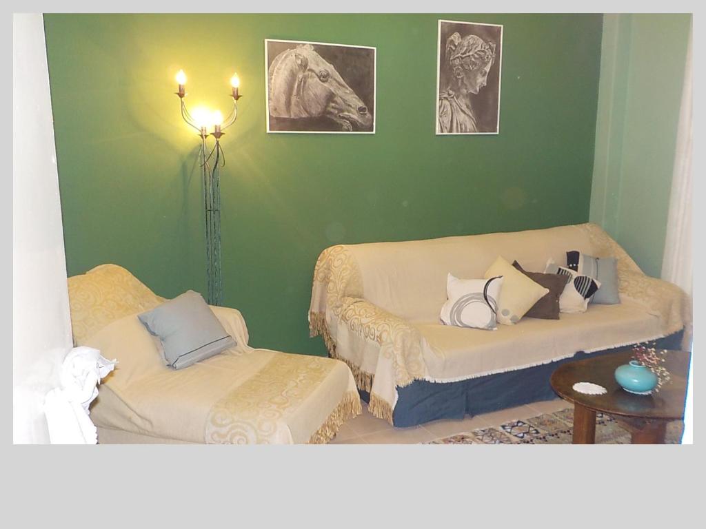 a green room with two beds and a lamp at G & G guesthouse in Edessa