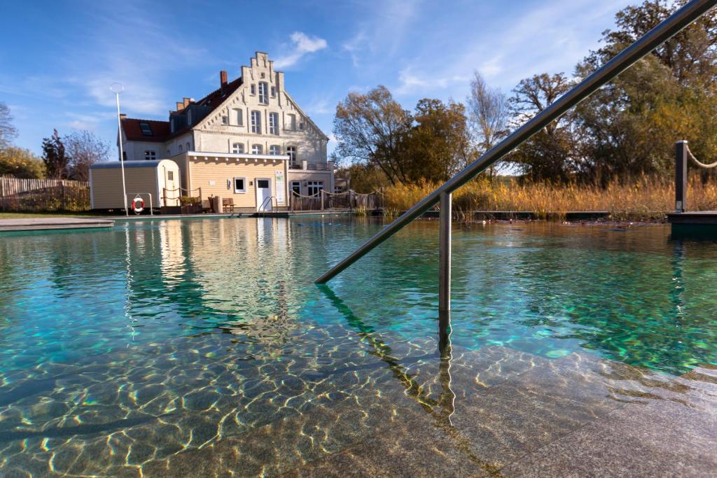 ein Haus inmitten eines Wasserpools in der Unterkunft Hotel Gutshaus Parin - Bio- und Gesundheitshotel in Parin