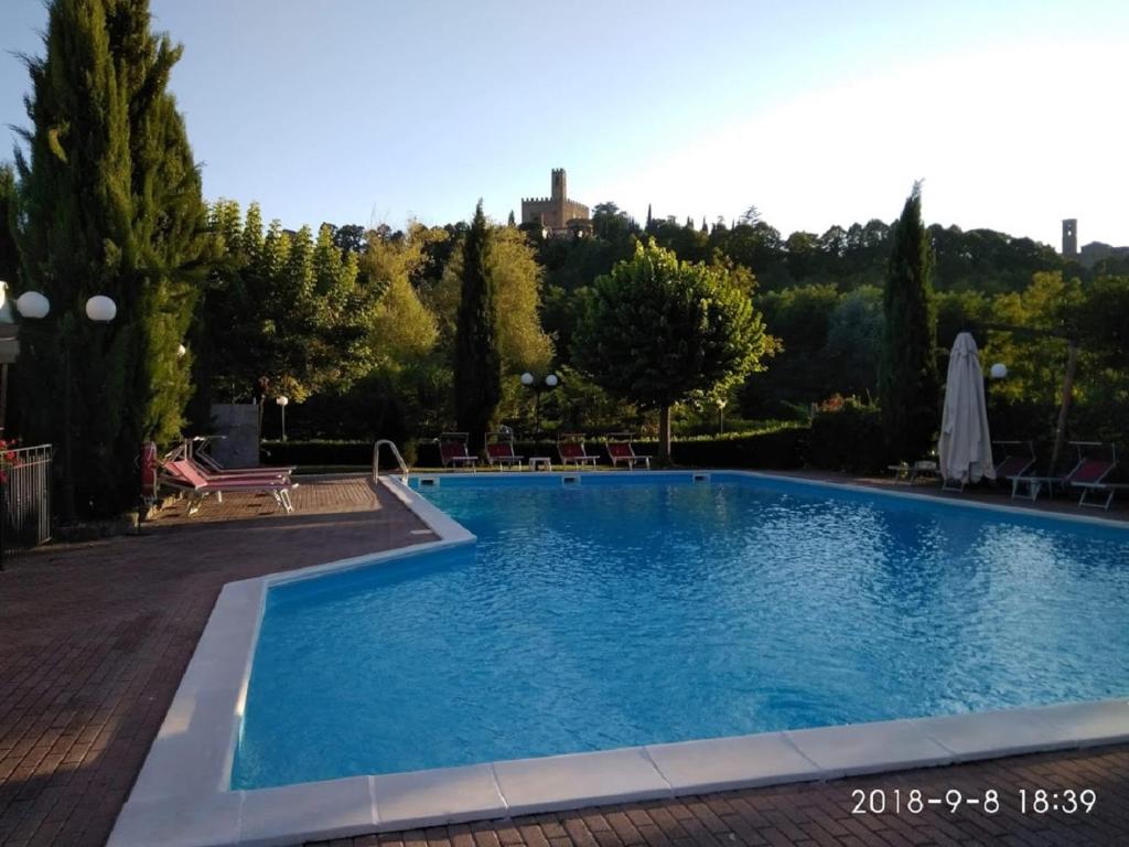 una grande piscina con acqua blu in un cortile di Parc Hotel a Poppi